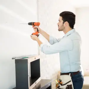 How to Mount a TV to the Wall and Hide Cords 6 A person using Drill Machine