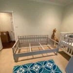 A room with two beds and a crib.