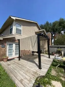 A patio with a pergola and a deck in the back yard.