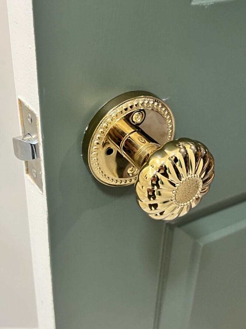 A door knob on the outside of a green door.