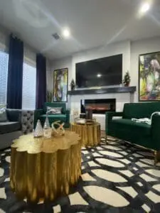 Cozy living room with green furniture and a fireplace, emphasizing the ambiance-enhancing services we provide, from minor repairs to furniture arrangement.