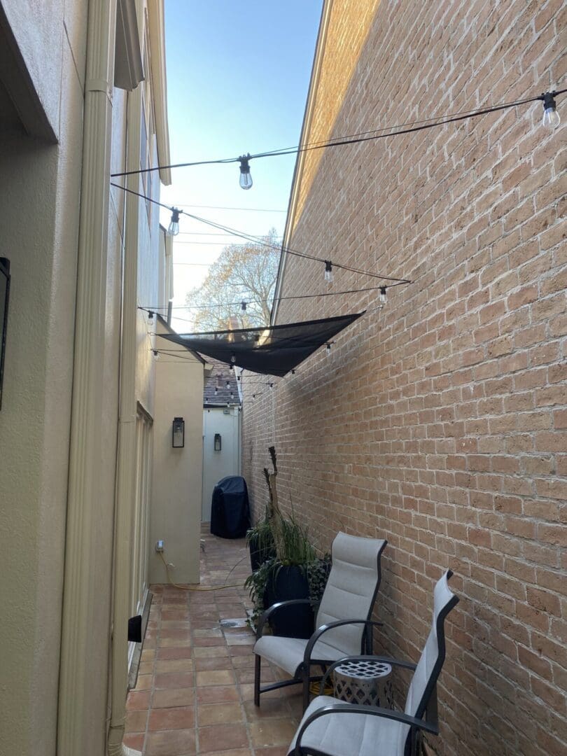 A patio with chairs and an umbrella hanging from the ceiling.