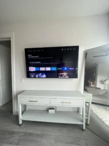 A tv mounted on the wall above a table.