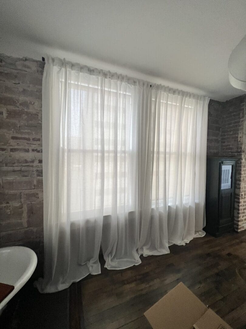 A room with two windows and brick wall