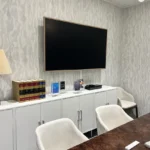 A tv mounted on the wall in front of a table.