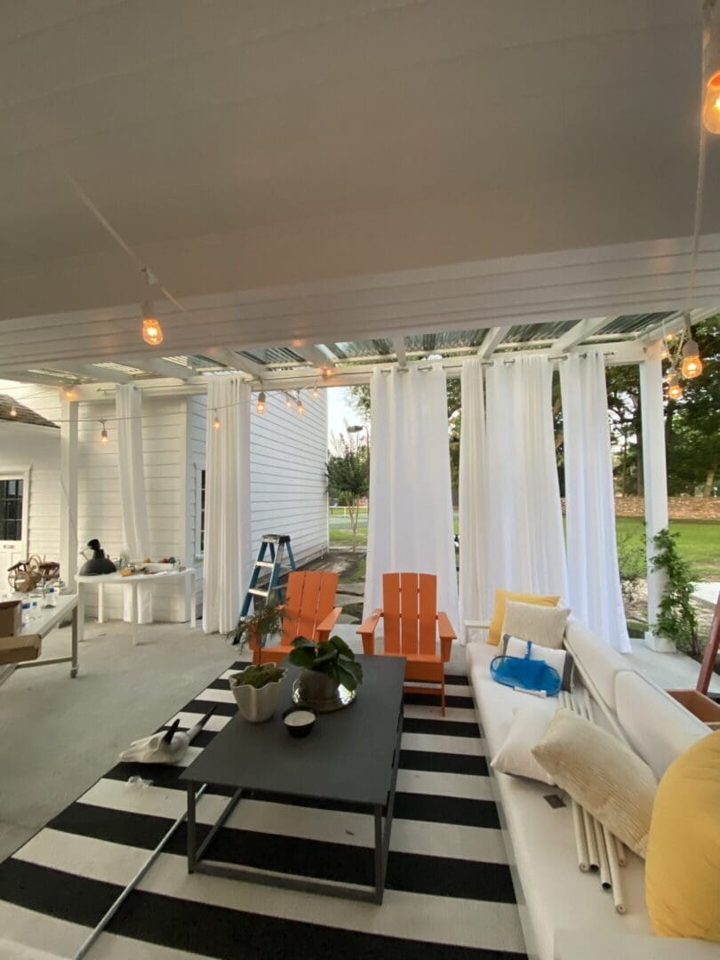 A patio with white curtains and black and white striped walls.