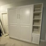A white cabinet with two doors and shelves.