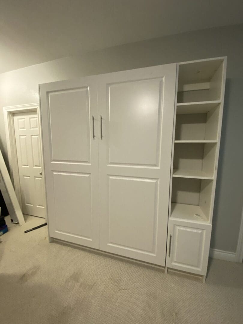 A white cabinet with two doors and shelves.