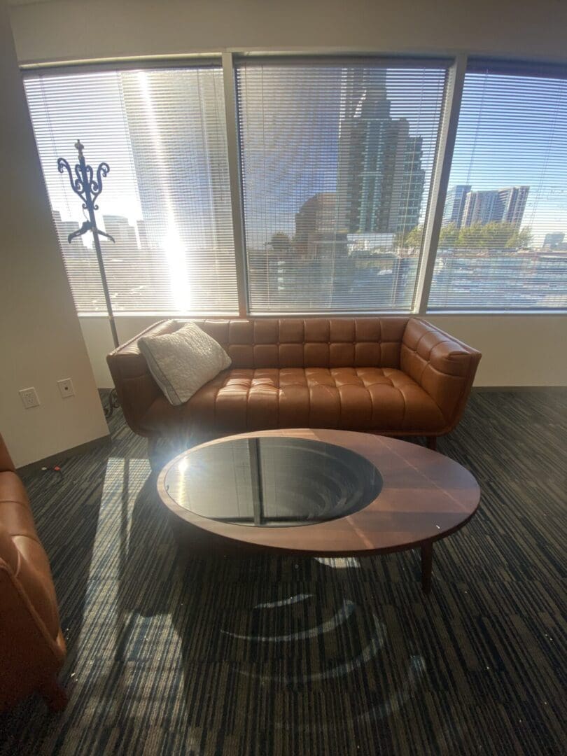 A couch and coffee table in front of large windows.