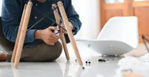 A person in the middle of Assembling a chair