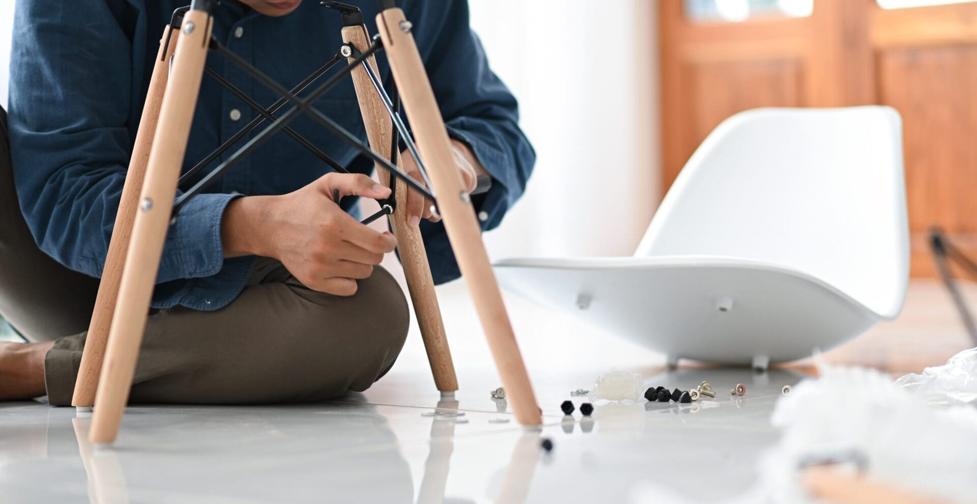 A person in the middle of Assembling a chair