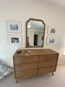 Bedroom with a dresser and arched mirror, showcasing personalized interior decorating services.