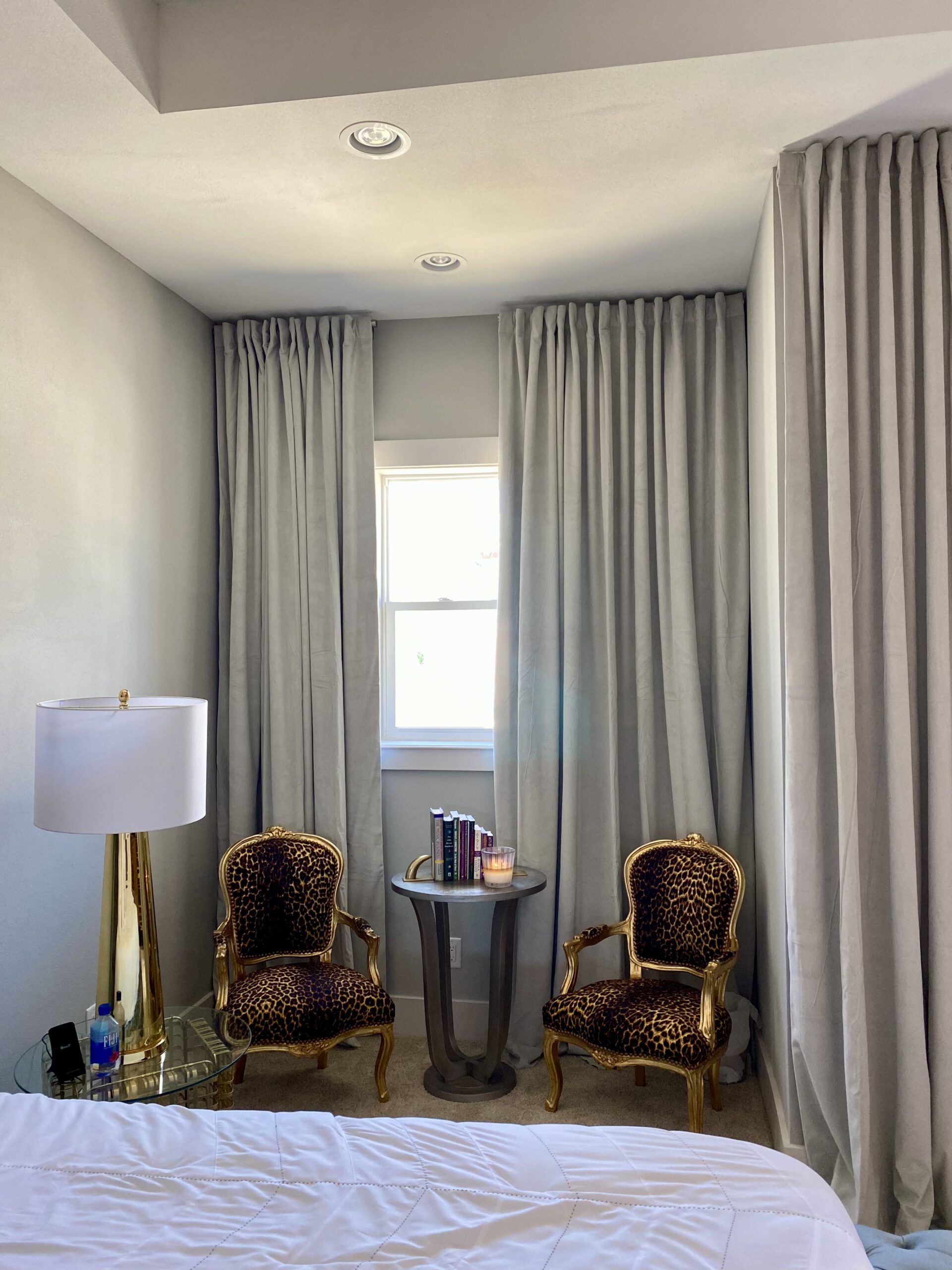 Bedroom with grey curtains and leopard print chairs, showcasing expert curtain installation for a bold, stylish look.