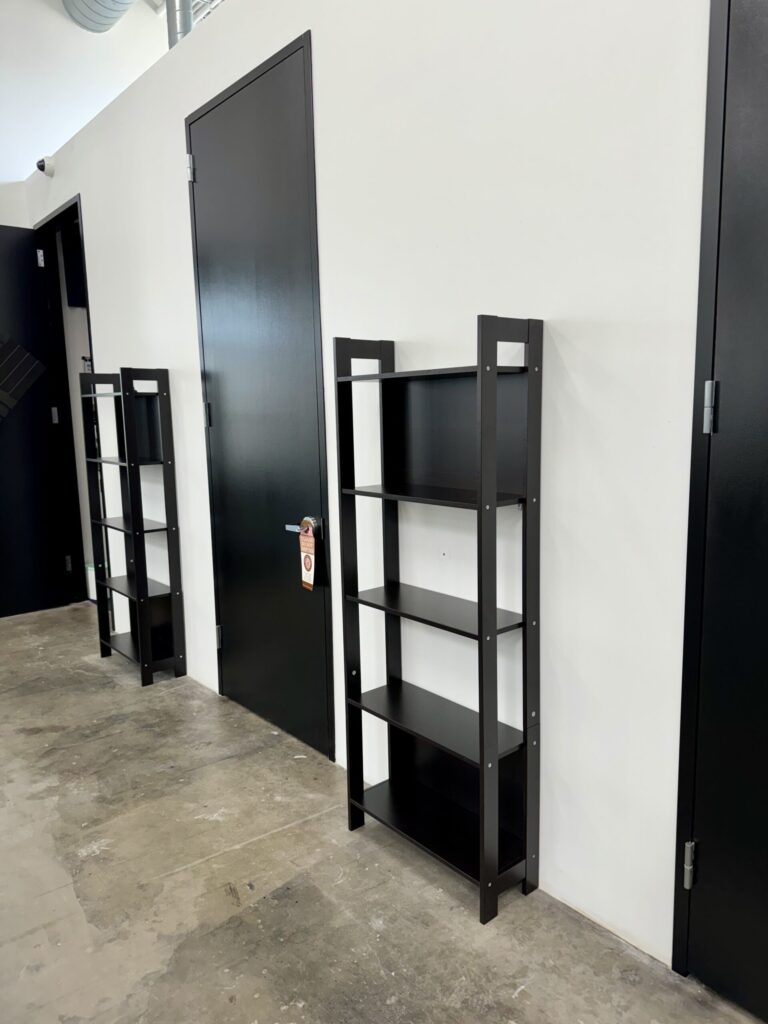 Assembly of black bookshelves in a Houston store, enhancing retail spaces.