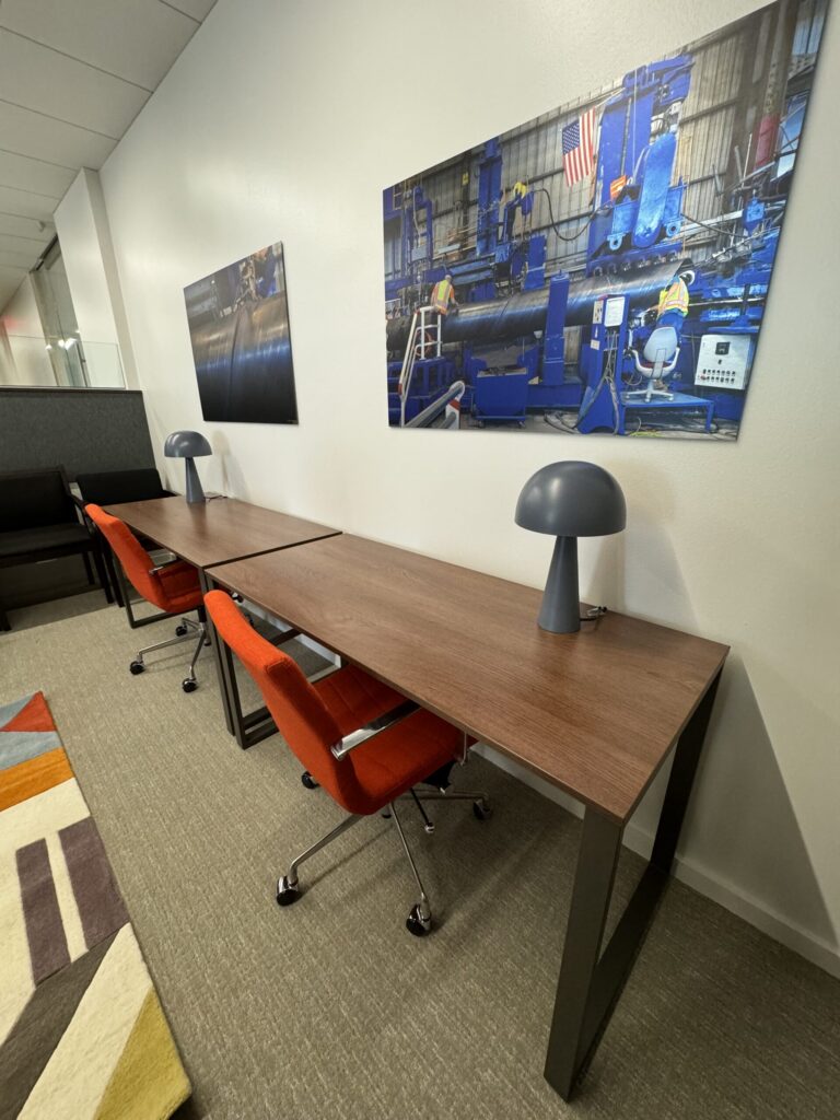 Modern office furniture assembly in Houston featuring long desks and orange chairs.