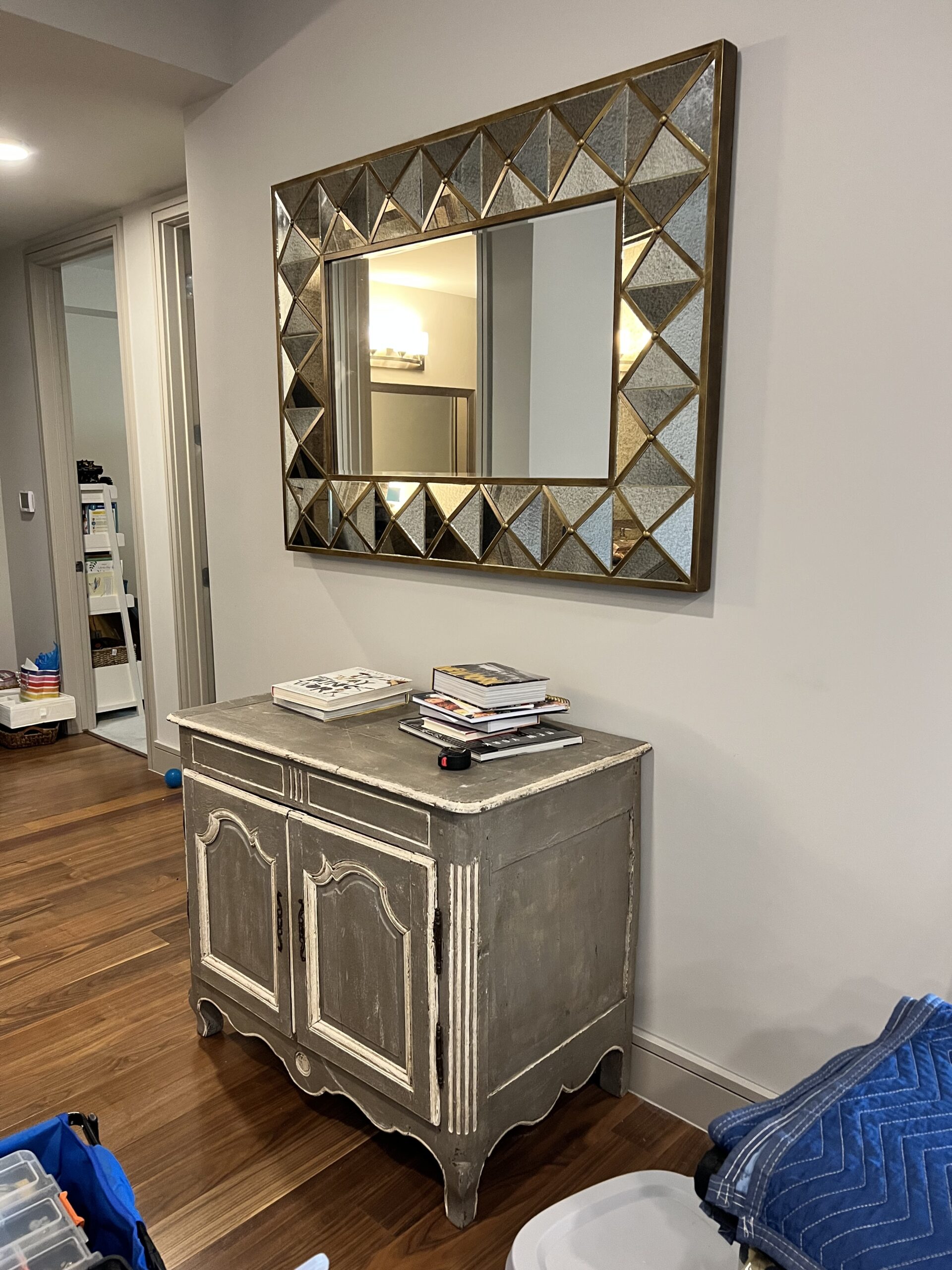 Vintage console table with a geometric mirror, highlighting our eclectic design and installation services.