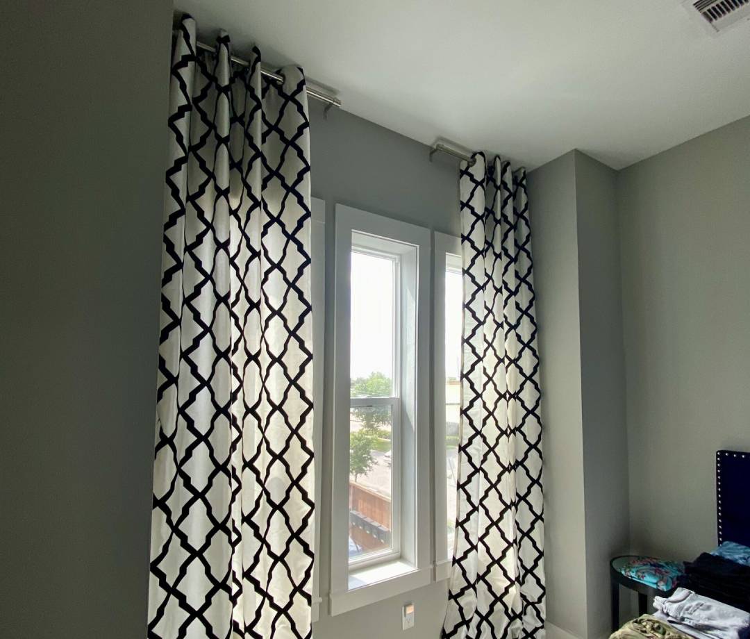 A modern bedroom with blackout curtains installed for maximum privacy and light control.