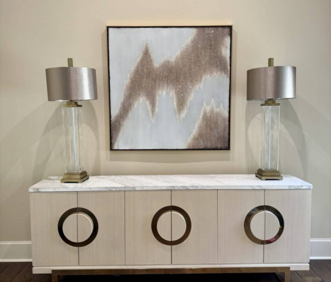 Large abstract painting professionally mounted above a console table, enhancing the living room.